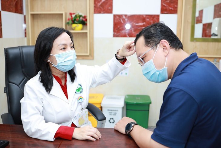 Bị hói đầu có nên đi cấy tóc? - Ảnh 1. Bác sĩ Bệnh viện Da liễu TP.HCM đang thăm khám và điều trị cho bệnh nhân - Ảnh: BVCC